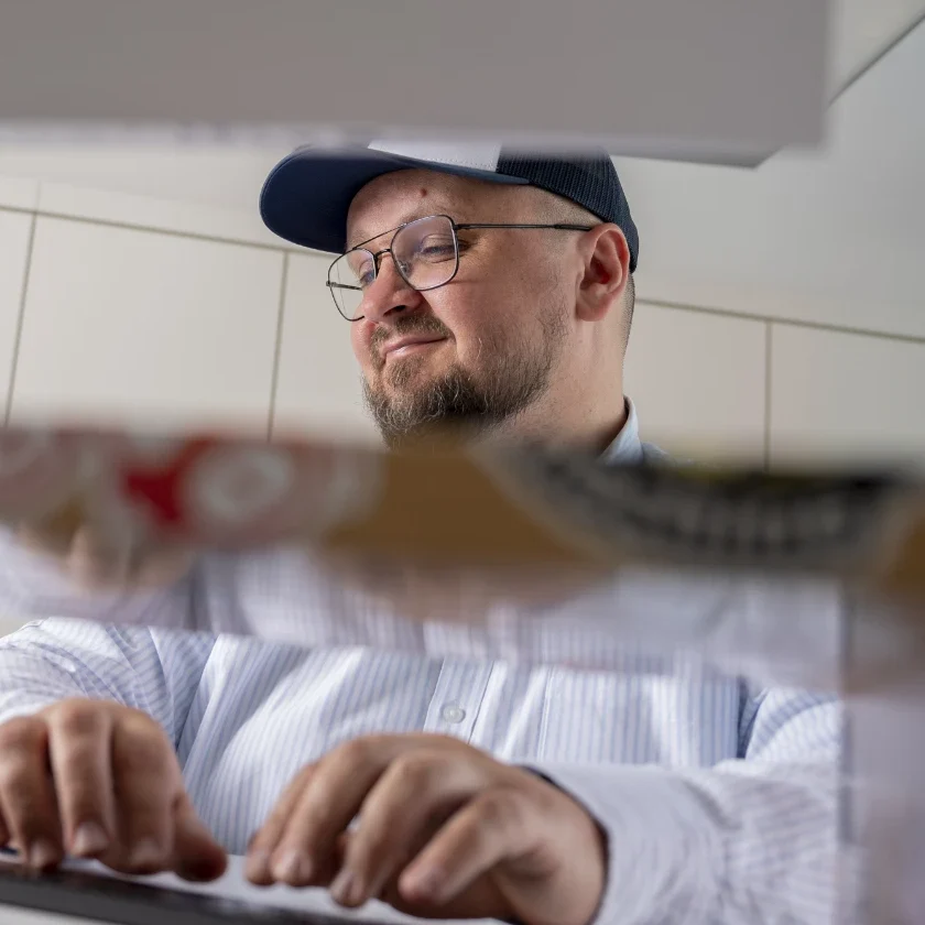 Dominik Plaszewski lächelnd am Schreibtisch